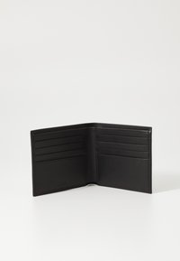 Portafoglio in pelle nera con una texture liscia, dotato di più scomparti per carte e un design aperto per un accesso facile. Marchio minimalista visibile.