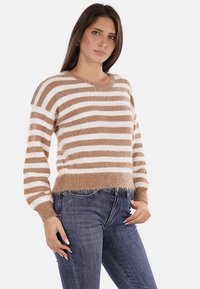 Maglione a righe in tonalità sabbia e bianco, realizzato in materiale morbido e peloso. Presenta un collo a barca e polsini a costine, con un orlo corto.
