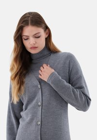 Grau gestrickte Strickjacke mit V-Ausschnitt, langen Ärmeln und fünf Knöpfen an der Vorderseite. Weiche Textur, leichtes Material, Unisex-Design.