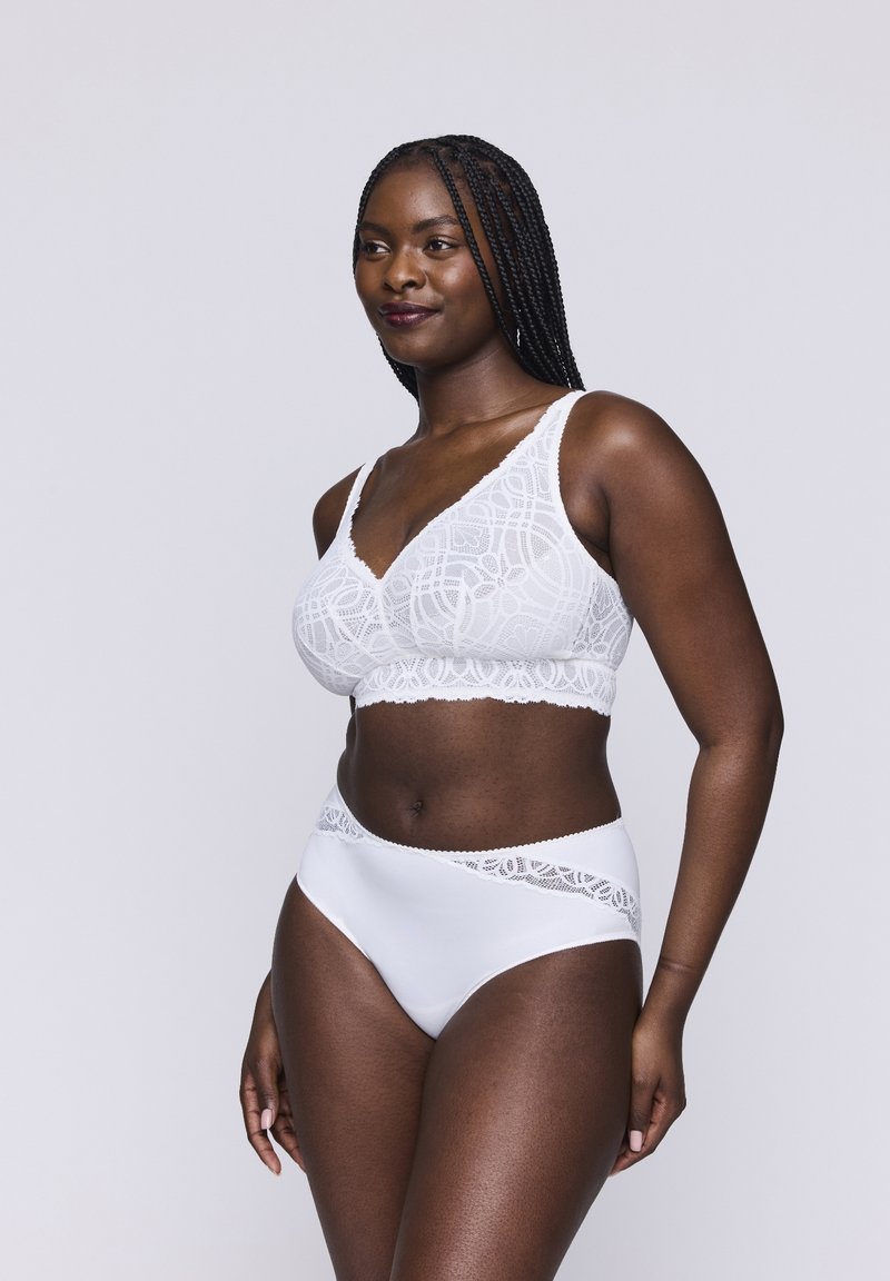 Bralette bianco in pizzo con scollatura a V e spalline larghe, abbinato a mutandine bianche a vita alta con dettagli in pizzo sulla cintura.