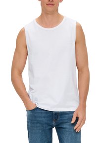 T-shirt en coton blanc sans manches avec un col rond, coupe décontractée, associé à un jean en denim bleu. Le tissu semble lisse, sans motifs.
