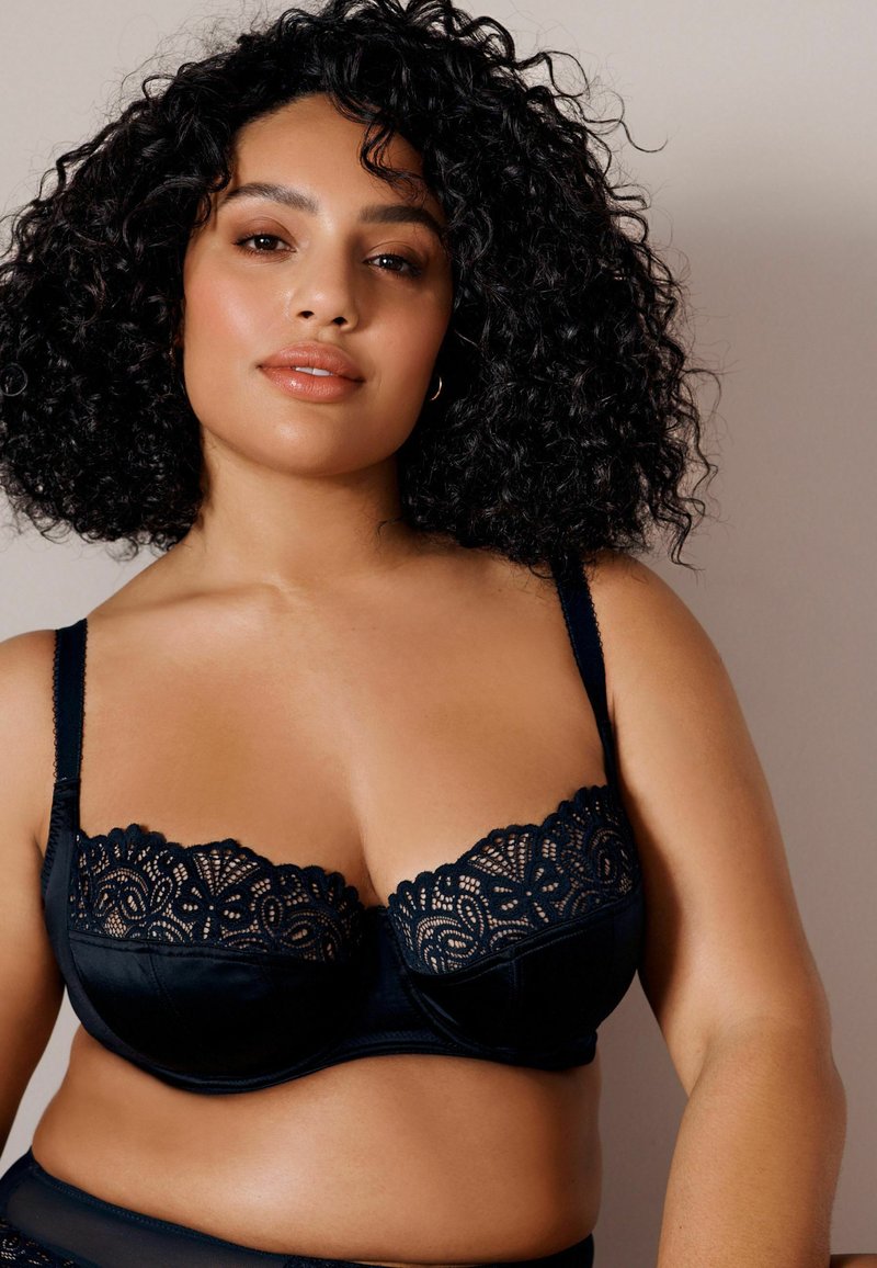 Sort bh med blonder detaljer langs den øverste kant, underwire støtte, justerbare stropper og en glat satin finish på kopperne.