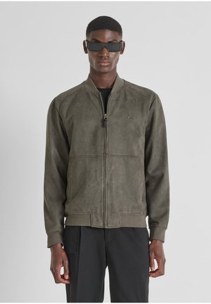 Giacca bomber in suede verde oliva con chiusura a zip completa, colletto e polsini a costine. Presenta un discreto logo accentato sul petto.