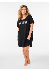 Čierna nočná košieľka s krátkym rukávom s tromi motívmi srdca v rôznych vzoroch a trblietavým textom nad nimi. Mäkká, ľahká tkanina, pohodlný strih.