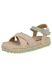 Sandalias de ante color tostado con correas entrelazadas, correa ajustable verde en el tobillo, tachuelas plateadas y suela de esparto. Suela texturizada verde.