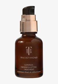 Bottiglia di vetro marrone con un tappo a pompa dorato. L'etichetta riporta "TRUE BOTANICALS SUPERSEA FIRMING & LIFTING TREATMENT" con una consistenza liscia.
