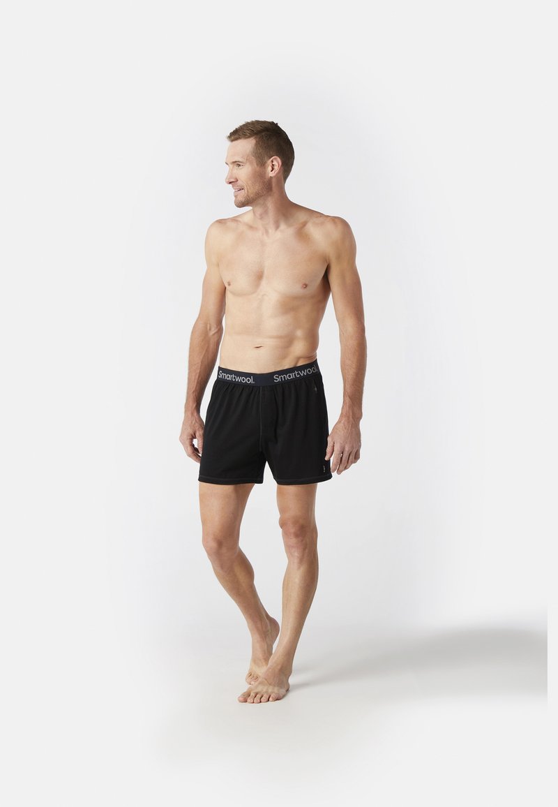 Zwarte boxershorts met een Smartwool-logo op de tailleband, gemaakt van zachte stof, met een relaxte pasvorm en een lengte tot halverwege de dij.