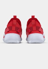 Scarpe sportive rosse con una finitura liscia, cinghie sul retro, un tallone imbottito e una suola bianca texturizzata con una leggera curvatura.