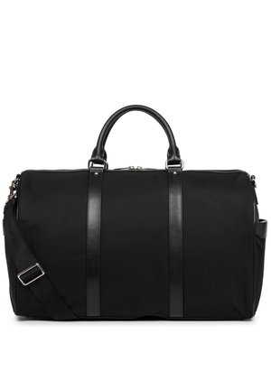 Sac de voyage noir en tissu avec une texture lisse, doté d'accents en cuir, de deux poignées supérieures et d'une bandoulière réglable.