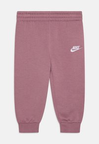 Pantaloni da jogging in cotone viola con cintura e polsini elastici. Presentano il logo bianco Nike nella parte superiore della coscia sinistra. Texture liscia.