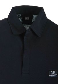 Polo shirt nera con colletto classico, tessuto testurizzato e un piccolo logo ricamato sul lato sinistro del petto. Design pulito e cuciture robuste.
