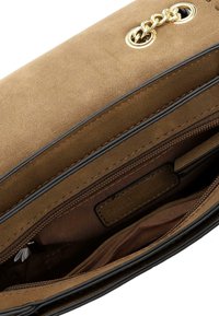 Interno di una borsa in suede marrone con una tasca con zip e foderato in tessuto liscio; presenta un accento in catena dorata e bordi neri a contrasto.