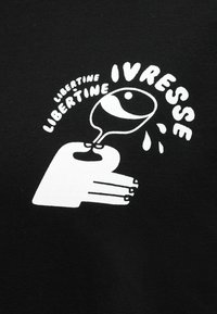 Στυλιζαρισμένο λευκό χέρι που κρατά ένα γέρνον ποτήρι κρασιού από το οποίο στάζουν σταγόνες, με τις λέξεις "LIBERTINE" και "IVRESSE" καμπυλωμένες γύρω σε μαύρο φόντο.