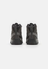 Czarne buty trekkingowe z teksturowaną cholewką, wyściełanym kołnierzem i wzmocnionym obcasem. Posiadają gumową podeszwę z głębokimi bieżnikami zapewniającymi przyczepność.