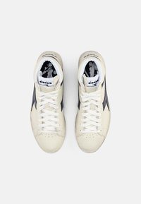 Baskets hautes en cuir crème avec des accents noirs. Présentent des lacets blancs, un bout perforé et une doublure intérieure à motifs.