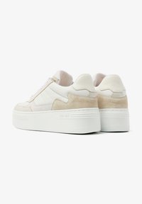 White sneaker featuring a combination of leather and suede materials, with a thick white platform sole and subtle stitching details.