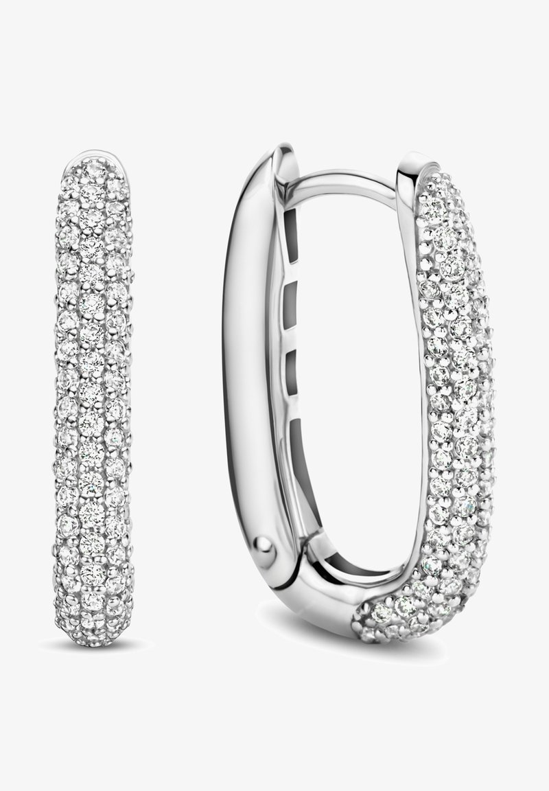 Silberne Creolen mit einem geschwungenen, glatten Design, die eine Oberfläche aufweisen, die mit mehreren kleinen, funkelnden klaren Edelsteinen besetzt ist.