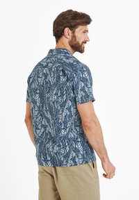Short-sleeve shirt in dark blue with a leaf pattern in light blue. Relaxed fit with a collar and a straight hem. Fabric appears lightweight.