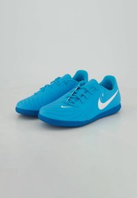 Zapatillas deportivas de color azul claro con parte superior sintética lisa, superficie texturizada, logo blanco de Nike y suela de goma flexible.