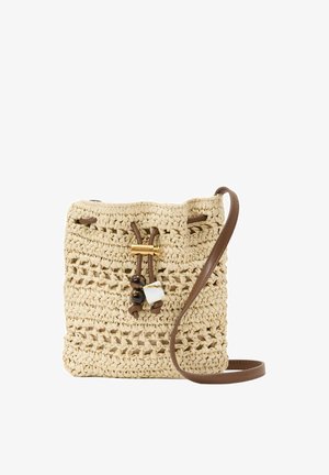 Bolso bandolera beige tejido con correa de cuero marrón, cierre de cordón y cuentas decorativas en la parte delantera, aislado sobre fondo blanco.