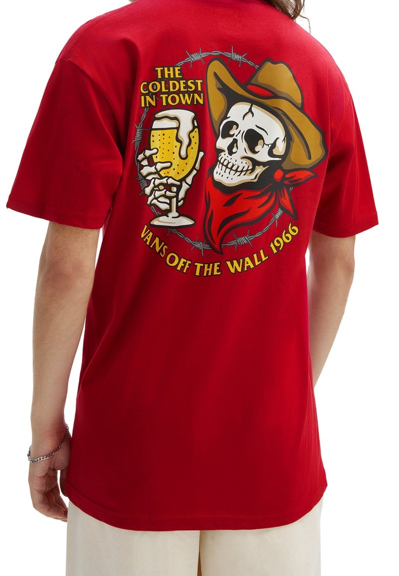 Camiseta de algodón roja con un gráfico de una calavera con un sombrero de vaquero, sosteniendo una bebida, acentuada con alambre de espino y texto arriba y abajo.