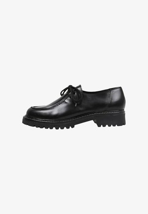 Zapato negro de cuero con cordones, con puntera redondeada, costuras prominentes y una suela gruesa y resistente. Textura suave con un diseño minimalista.