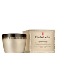 Crema Ceramide Premiere in un barattolo di vetro satinato con un coperchio con accenti dorati, accompagnata da una scatola coordinata nei toni oro e beige.