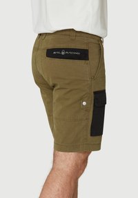 Pantalones cortos verde oliva con bolsillo de carga negro, con un parche de logo, botones laterales y costuras cosidas. Hechos de un tejido duradero, ajuste clásico.