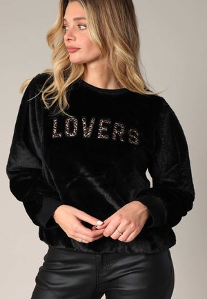 Sweatshirt noir en velours avec "LOVERS" en imprimé léopard sur le devant, à manches longues et coupe décontractée. Texture lisse, col ras du cou.