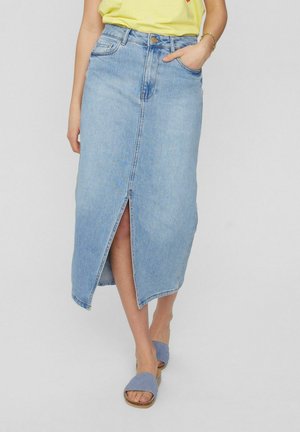 Light blue denim skirt with a front slit, high waist, and stitched pockets. Worn with grey sandals and a yellow shirt.