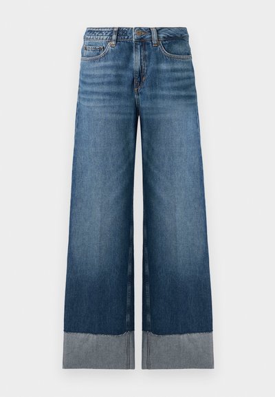 Jean bleu à jambes larges avec un dégradé de denim plus foncé à plus clair, présentant un ourlet brut et des détails de couture subtils. Design classique à cinq poches.