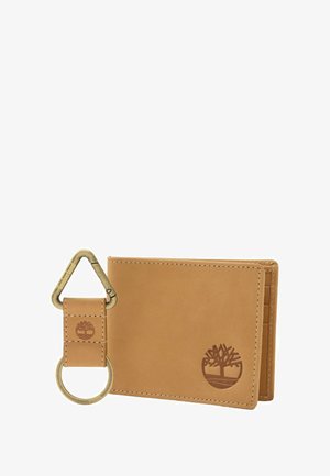 Portafoglio in pelle marrone con scomparti per carte e logo ad albero in rilievo; include un portachiavi abbinato con clip metallica triangolare e anello.