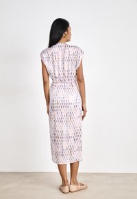 Flowy, pastel-colored midi dress with short sleeves, elastic waist, and vertical pattern in purple and pink hues. Smooth, lightweight fabric.
