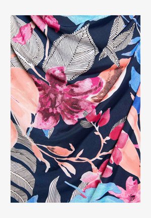 Tissu bleu marine avec de grandes fleurs tropicales roses, pêche et bleues, ainsi que des feuilles rayées en noir et blanc dans un motif floral audacieux.