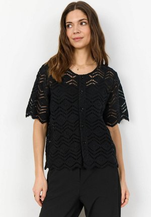Cardigan in pizzo nero con un motivo a zigzag, maniche corte e chiusura a bottoni. Il tessuto presenta un aspetto delicato e testurizzato.
