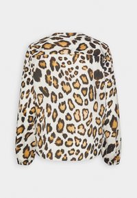 Camicia con stampa leopardata su sfondo bianco, caratterizzata da macchie marroni e nere. Maniche lunghe con polsini elastici e orlo arrotondato.