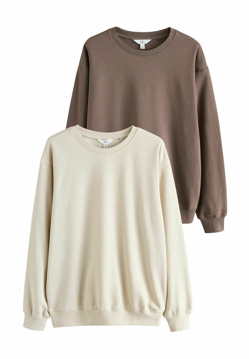 Sono mostrati due felpe: una color beige chiaro e l'altra marrone scuro. Entrambe presentano un collo a giro e polsini e orlo a costine.
