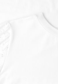 Haut blanc sans manches avec un col rond et des détails en dentelle sur les épaules sur fond blanc.