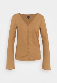 Haut côtelé à manches longues et col en V de couleur brun clair, doté d'une fermeture avant à boutons et d'un tissu doux et texturé.