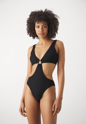 Maillot de bain une pièce noir avec bretelles larges, décolleté en V, côtés découpés et accent en forme d'anneau central ; tissu texturé avec une finition lisse.