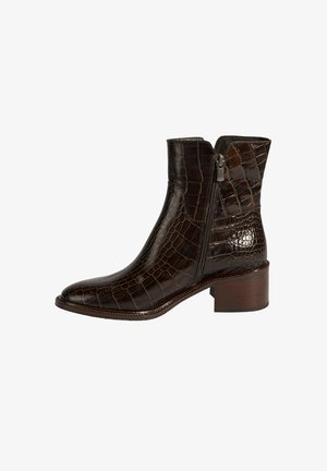 Bottine en cuir embossé crocodile brun avec une fermeture éclair latérale et un talon en bois empilé. Bout effilé et surface texturée.
