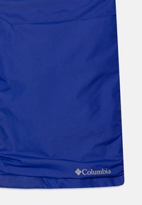Plava Columbia suknja s glatkom, blago sjajnom teksturom. Ima logo u donjem desnom kutu i jednostavan, minimalistički dizajn.