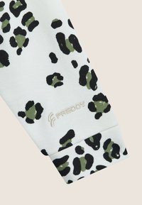 Tessuto bianco con un motivo leopardato nero e verde oliva, con il logo "Freddy" in rilievo sul polsino.