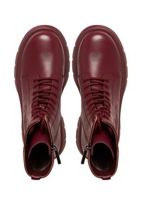 Stivaletti alla caviglia in pelle bordeaux con finitura lucida, punta tonda, chiusura con lacci e zip laterali per un accesso più facile. Suola in gomma spessa.
