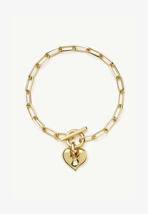 Zelta ķēdes aproce ar pagarinātām saitēm un aizdari, rotāta ar pulētu sirds formas piekariņu.