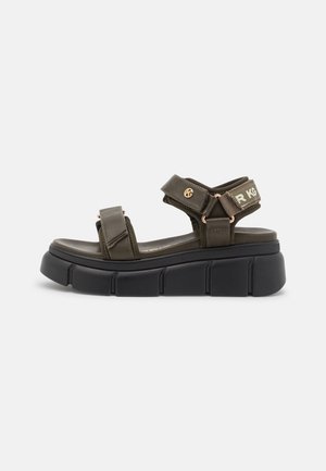 Olive green platform sandals with wide adjustable straps, featuring rose gold hardware and a textured black sole.