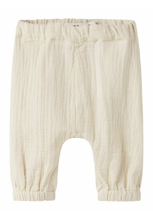 Bløde beige babybukser med elastisk talje og manchetter, lavet af løst, tekstureret stof med drophælt-design.