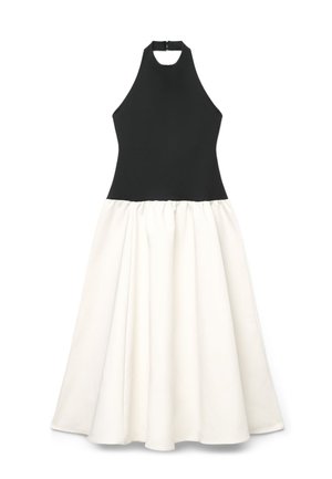 Vestito nero senza maniche con collo alto a halter e gonna bianca arricciata a ruota che arriva fino alla caviglia.