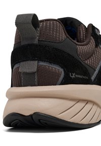 Bruine sneaker met gestructureerde stof, suedetoevoegingen en een beige tussenzool. Bevat een trekhaak aan de hiel en een dikke rubberen loopzool.
