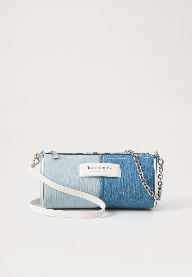 Denim crossbody bag featuring a gradient of light to dark blue, a white leather strap, silver chain accents, and a logo tag. Zipper closure.